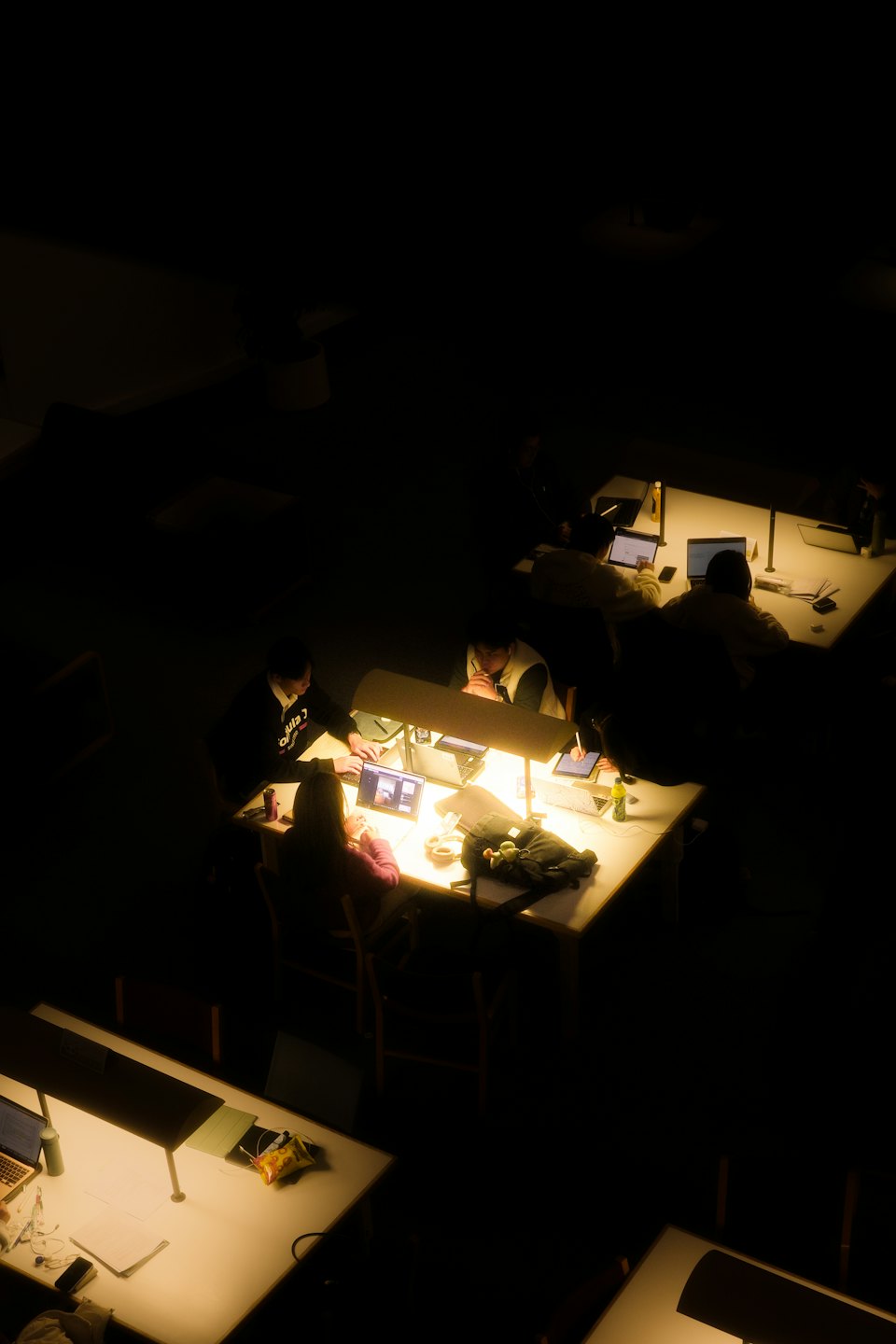 Persone che lavorano al computer su scrivanie in un luminoso spazio di lavoro interno.